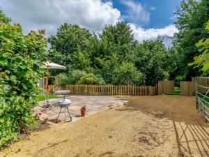 a patio with a table and a chair in a yard at 1 Bed in Sherborne 83499 in Wincanton