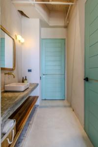 baño con puerta azul y lavamanos en Bondo Estudio en Cartagena de Indias