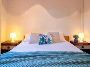 a bedroom with a large white bed with two lamps at Apartment B-0-3 - Marineledda by Interhome in Golfo Aranci