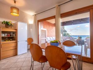 a kitchen with a table and chairs and a refrigerator at Apartment B-0-3 - Marineledda by Interhome in Golfo Aranci