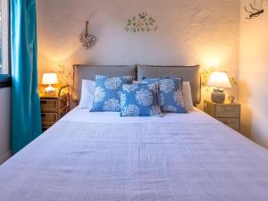 a bedroom with a bed with blue pillows at Apartment E-1-4 - Marineledda by Interhome in Golfo Aranci