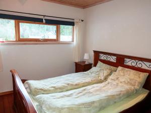 1 cama en un dormitorio con ventana en Chalet Heggland Huset - FJH616 by Interhome, en Heggland