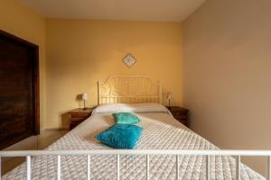 a bedroom with a white bed with a blue pillow at La Casetta dei Gerani in Montemarano