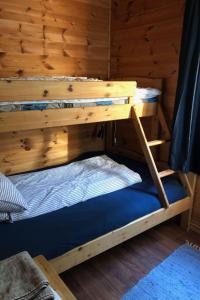 a bunk bed in a cabin with a wooden wall at Holiday Home Kalavåg by Interhome in Kalavåg