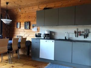a kitchen with a counter and a table with chairs at Holiday Home Kalavåg by Interhome in Kalavåg