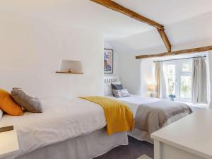 a white bedroom with two beds and a window at 2 bed property in Wadebridge 87231 in Egloshayle