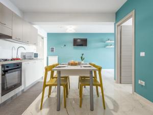 une cuisine avec une table blanche et des chaises jaunes dans l'établissement Apartment Sicilia by Interhome, à Balestrate