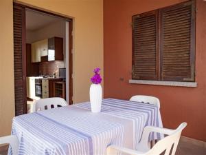 特里尼塔迪亞古圖的住宿－Apartment Tanca Torre 60P by Interhome，一张桌子,上面有花瓶,上面有紫色花