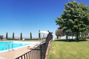 une piscine avec bancs et une clôture à côté d'une cour dans l'établissement Apartment Pontevecchio by Interhome, à Asciano