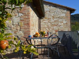 une table et des chaises sur une terrasse avec un mur en briques dans l'établissement Apartment Pontevecchio by Interhome, à Asciano
