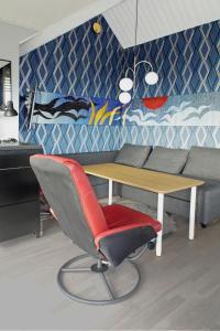 sala de estar con mesa y silla roja en Holiday Home Utsikten - OEL100 by Interhome, en Byxelkrok