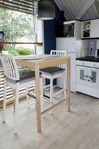 比克瑟爾克魯克的住宿－Holiday Home Utsikten - OEL100 by Interhome，厨房配有木桌和两把白色椅子