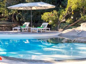 due sedie e un ombrellone accanto a una piscina di Holiday Home Stazzu lu Bulioni by Interhome a Arzachena Altre 61 foto