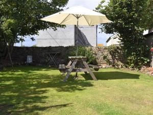 a picnic table with an umbrella in a yard at 2 bed property in Mawbray Cumbria SZ214 in Mawbray