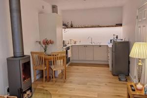 a kitchen with a stove and a table with a fireplace at Rural Cornish Cottage in Truro