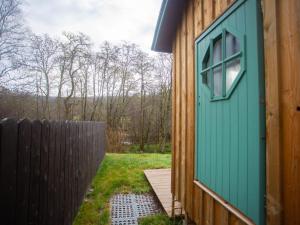una puerta verde al lado de una casa en Chalet Plodda 4 by Interhome en Drumnadrochit