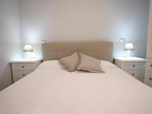 sypialnia z dużym białym łóżkiem z 2 stolikami nocnymi w obiekcie Apartment Bilo Satta by Interhome w mieście Trinità dʼAgultu