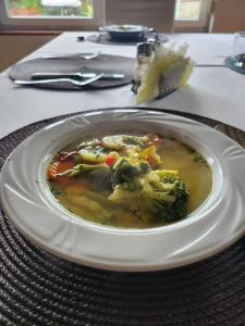 a plate of soup with broccoli on a table at Hotel Kos in Kosobudz