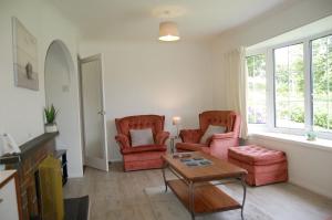 sala de estar con 2 sillas y mesa en Hafan Y Talgarth bungalow at Plas Talgarth resort, en Pennal