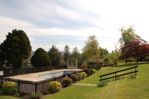 un jardín con piscina y una valla en Hafan Y Talgarth bungalow at Plas Talgarth resort, en Pennal