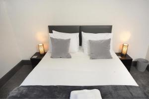 um quarto com uma grande cama branca e 2 candeeiros em Executive 8 Beds 2 Bath Home Contractors Parking em Southampton