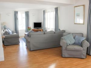 uma sala de estar com um sofá e uma cadeira em Cindy's Retreat em Hope-Cove