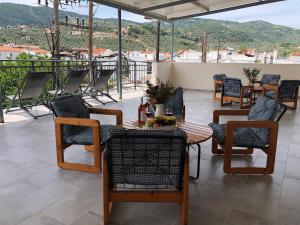 a patio with a table and chairs on a balcony at Central Guest House Skiathos in Skiathos Town