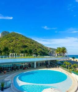 a large swimming pool in front of a resort at Quarto no Hotel Nacional com vista mar para a Praia de São Conrado, RJ in Rio de Janeiro