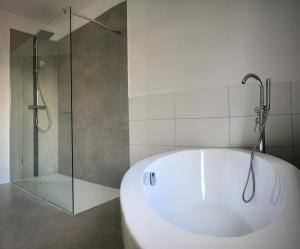 BraunshausenにあるSchneiders Ferienwohnung 1のバスルーム(白いバスタブ、シャワー付) +2枚の写真