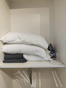 a pile of white pillows sitting on a shelf at [ROME 15min]Modern Accommodation, Airport,Station,LinkHouseCiampino in Ciampino +27 photos