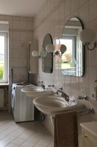 uma casa de banho com 2 lavatórios e uma máquina de lavar roupa em Schneiders Ferienwohnung 4 em Braunshausen