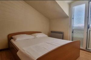 uma cama num quarto com uma grande janela em 3 Bedroom Ana's Rest Apartment by the sea em Kaštela