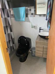 Łazienka z czarną toaletą i umywalką w obiekcie Nenes PLace w mieście Cueva de Morgan