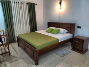 ein Schlafzimmer mit einem Bett und einem Stuhl darin in der Unterkunft Dickwella Green Villa in Dikwella