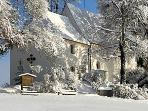 a white house with snow on the side of it at Neue, ruhige Ferienwohnung in Wolfegg