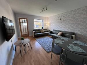 a living room with a couch and a table at Frensham House in Dallington