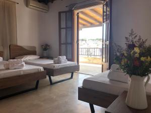 Zimmer mit 2 Betten und einer Blumenvase in der Unterkunft Central Guest House Skiathos in Skiathos-Stadt
