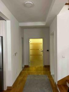 an empty room with a yellow door and wooden floors at Luxurious House for Rent in Pristina