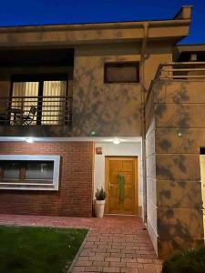 ein Backsteinhaus mit einer Tür und einer Veranda in der Unterkunft Luxurious House for Rent in Pristina
