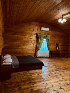 una camera con un letto in una stanza con una finestra di Райский Дворик a Pogreby