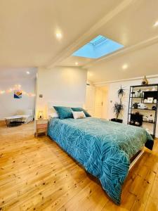 a bedroom with a bed with a blue comforter at La Croisée des Vignobles - Gîte Fins Bois 
