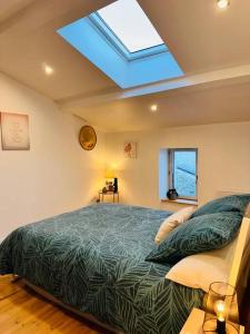 a bedroom with a large bed and a skylight at La Croisée des Vignobles - Gîte Fins Bois 