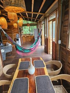 a hammock in a room with a table and chairs at La Casa Del Mono in Minca
