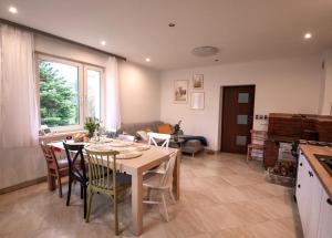a kitchen and living room with a table and chairs at Domek Wilgówka in Jastrzębia