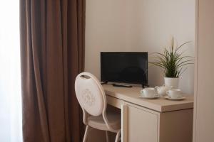 a desk with a computer monitor and a chair at Zeta Resort Donnalucata in Scicli