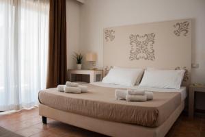 a bedroom with a large bed with towels on it at Zeta Resort Donnalucata in Scicli