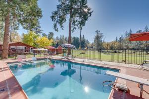 a large swimming pool in a yard with trees at Cozy Placerville Cottage with Pool on Livestock Farm in Placerville