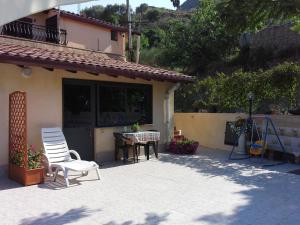 un patio con 2 sillas y una mesa frente a una casa en A Casa da Paola en Taormina