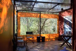 Habitación con ventana grande y 2 sillas. en Glamping Octógono, en Río Ceballos