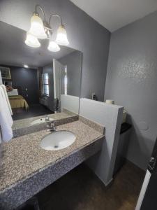 a bathroom with a sink and a mirror at Budget Inn Buffalo in Buffalo